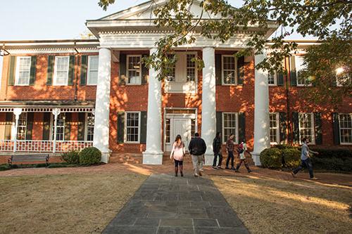 Smith Hall on a sunny day with students walking to and from the building