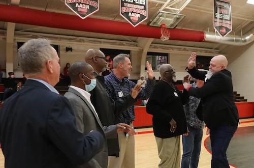 Members of the 1982-83 championship team greet each other on the court.